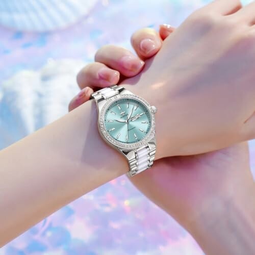 Elegant wristwatch with silver strap on person's wrist.