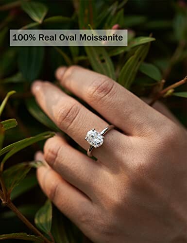 Hand wearing an oval moissanite ring.