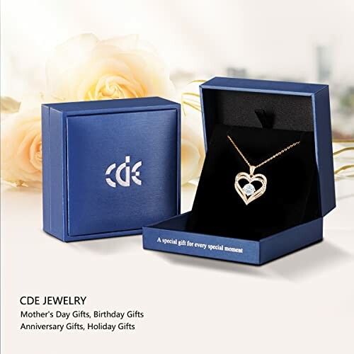 Heart pendant necklace in a blue gift box with roses in the background.