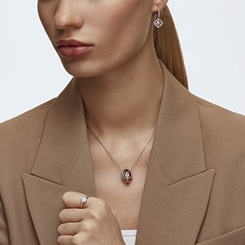 Woman wearing a necklace, earrings, and ring.