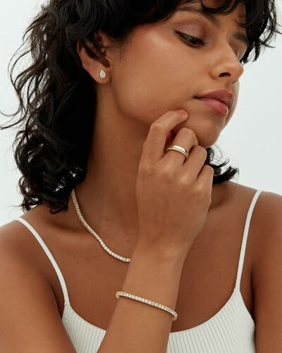 Woman wearing earrings, necklace, bracelet, and ring
